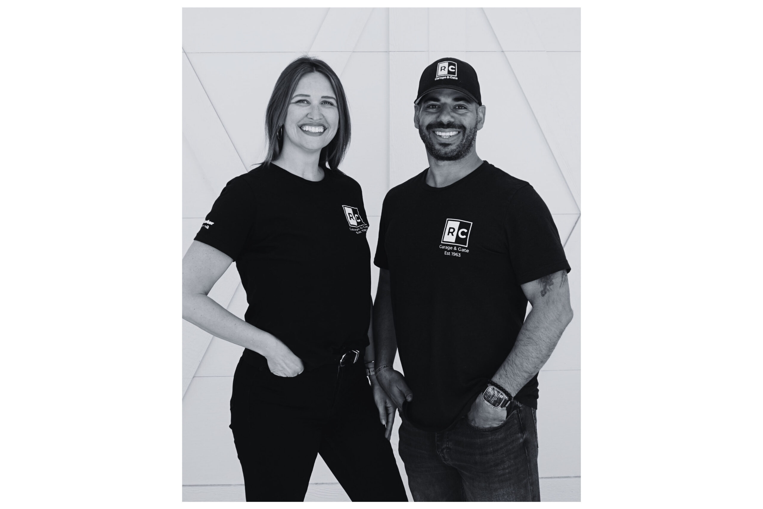 Two smiling individuals wearing branded black T-shirts and hats, standing against a modern geometric background.