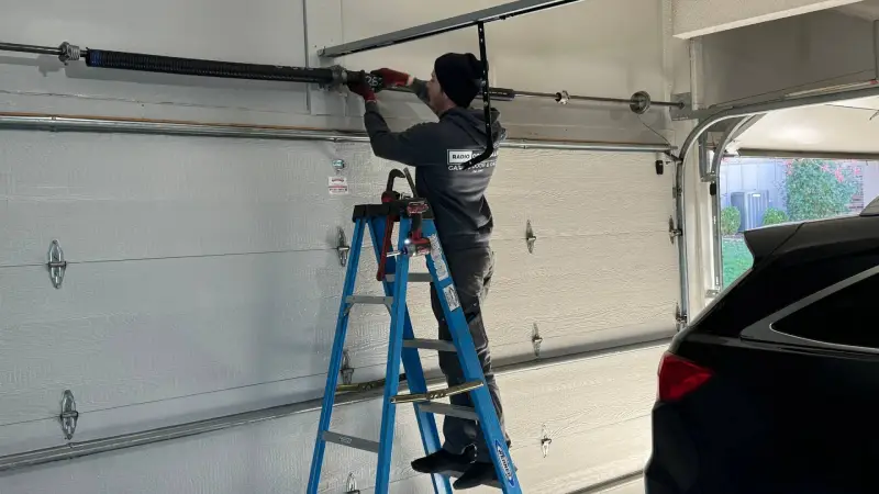 Expert performing garage door spring installation repair, using precision tools to adjust tension and improve door safety.