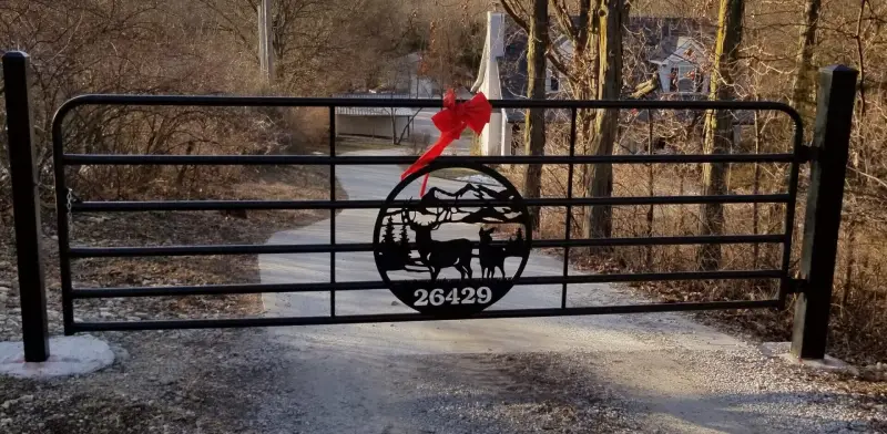Custom metal gate with a scenic wildlife design, adding security and aesthetic appeal to the driveway entrance.