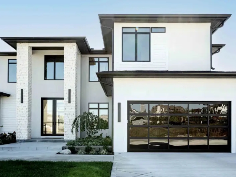 Modern home with a black glass garage door, emphasizing why investing in quality garage door repairs is essential.